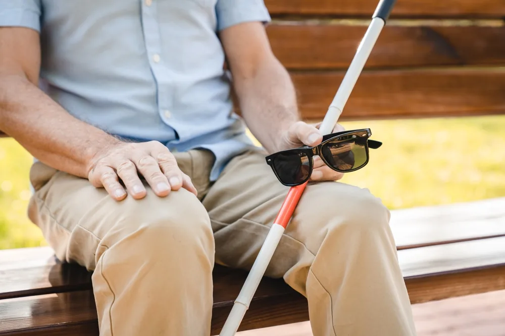 visually impaired man, closeup to walking stick