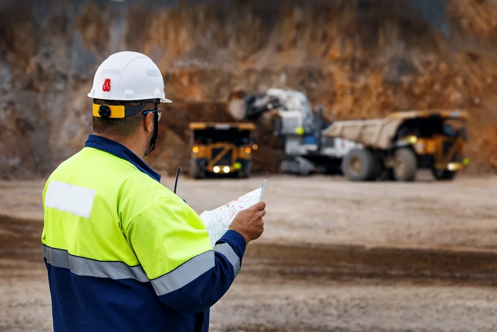 construction worker looks onto machines on a construction site
