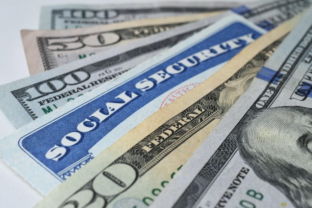 Zoom a una tarjeta de seguro social y dinero en efectivo.