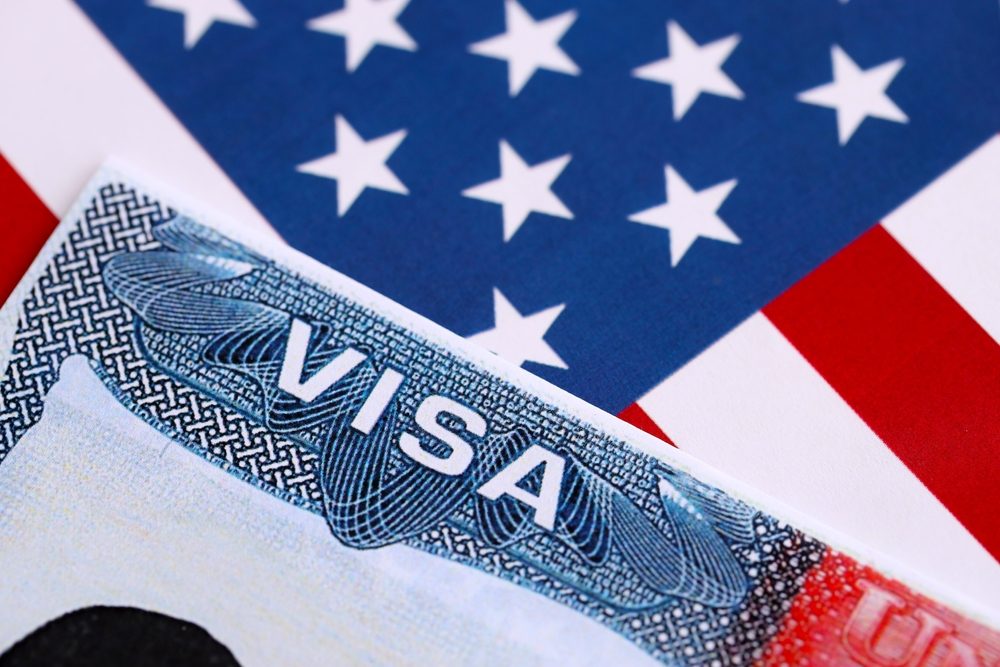 Zoom a una visa y bandera de EEUU.
