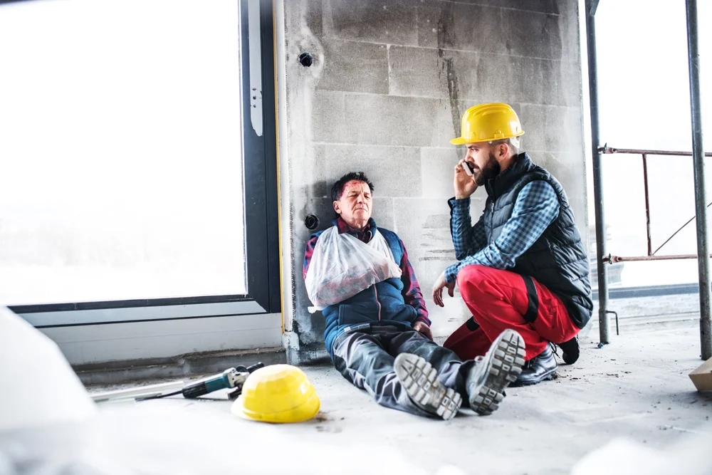 Construction worker calls an ambulance after coworker had an accident.