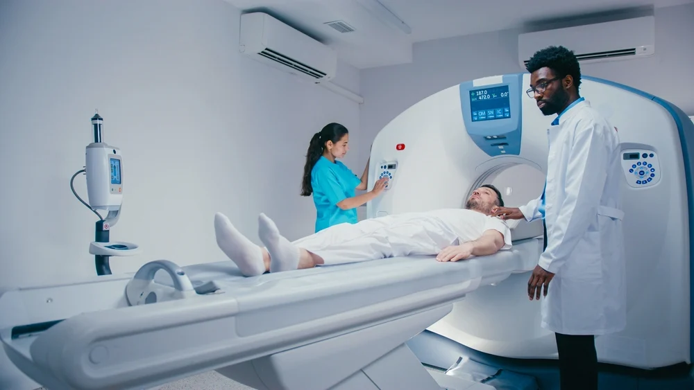 Doctors prepare a male patient to get an MRI.
