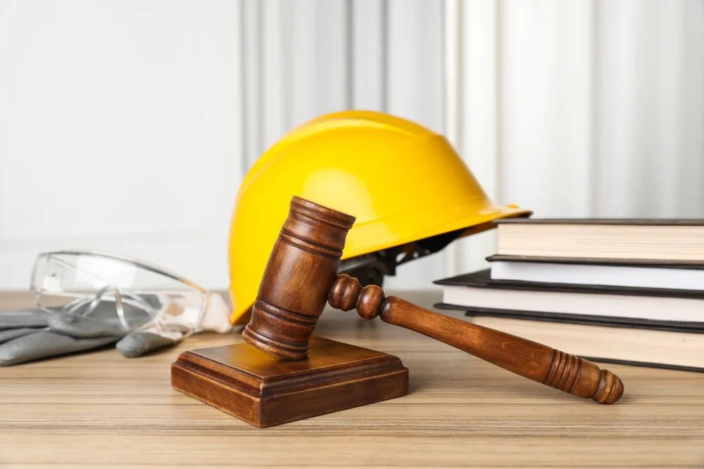Closeup of judge gavel with construction gear in the back.