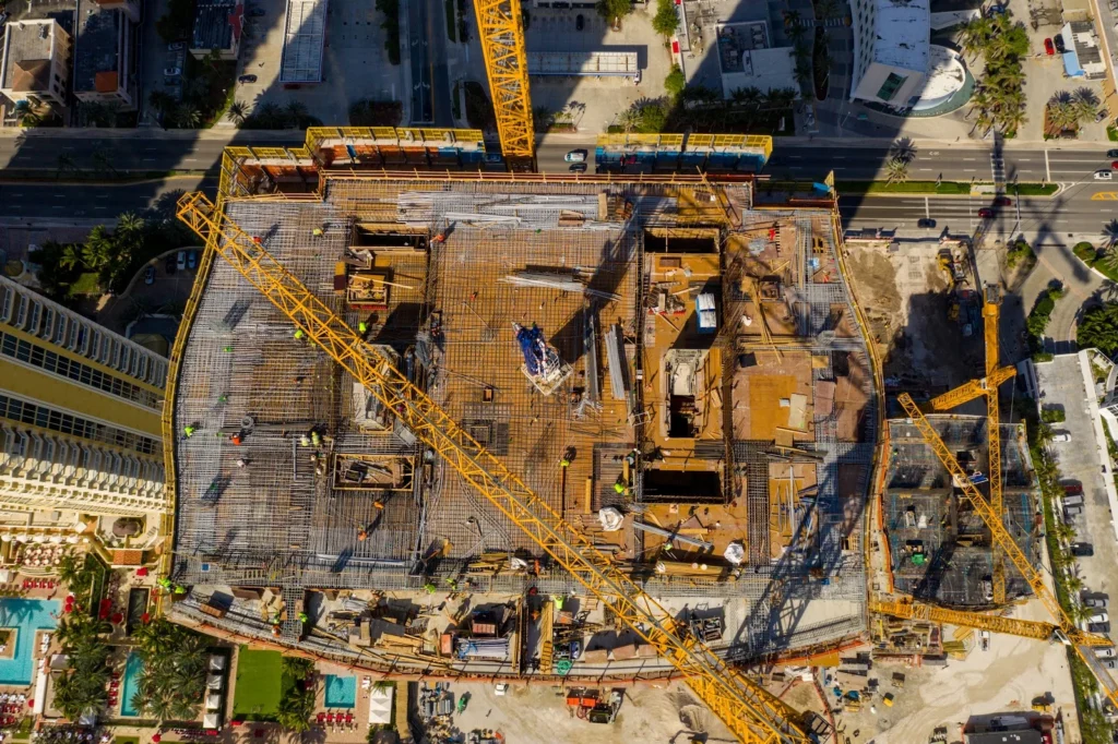 Vista aérea de una obra de construcción con objetos cayendo.