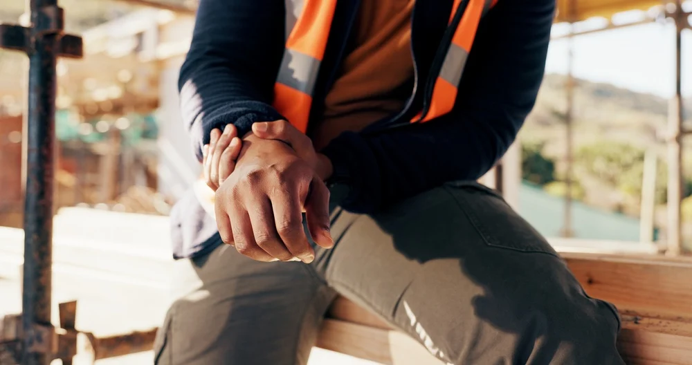 trabajador de construcción se toma la mano adolorido