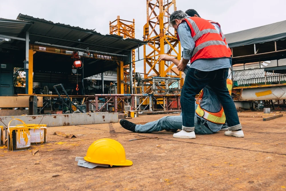 Construction workers help partner get up after accident