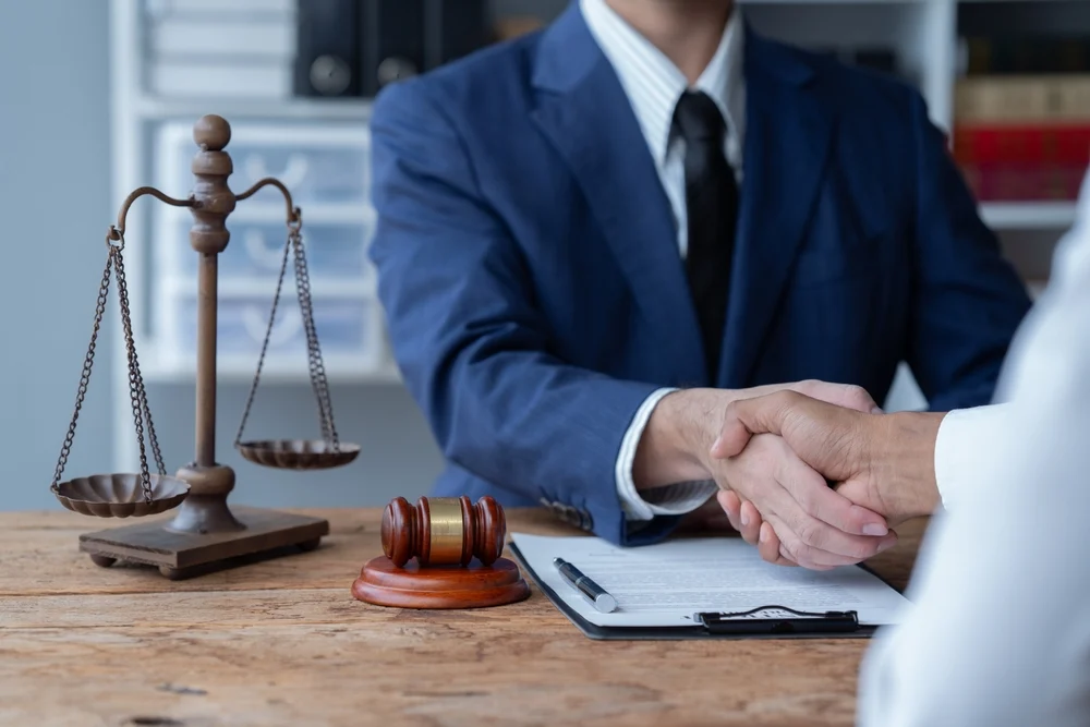 Lawyer shakes hand with client, construction accident lawyer